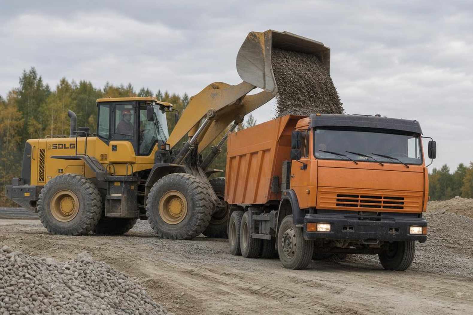 фронтальный погрузчик SDLG LG956L разгружает щебень в кузов КАМАЗа