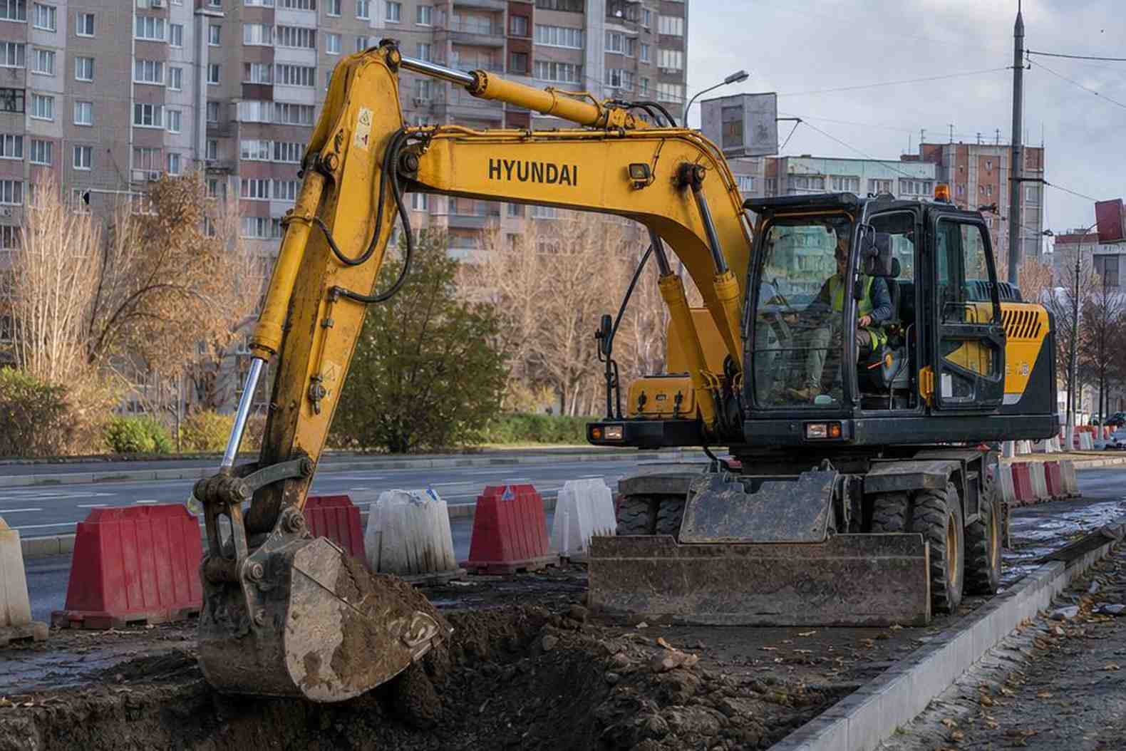 Колёсный экскаватор Hyundai R140W-9S работает в городе у бордюра
