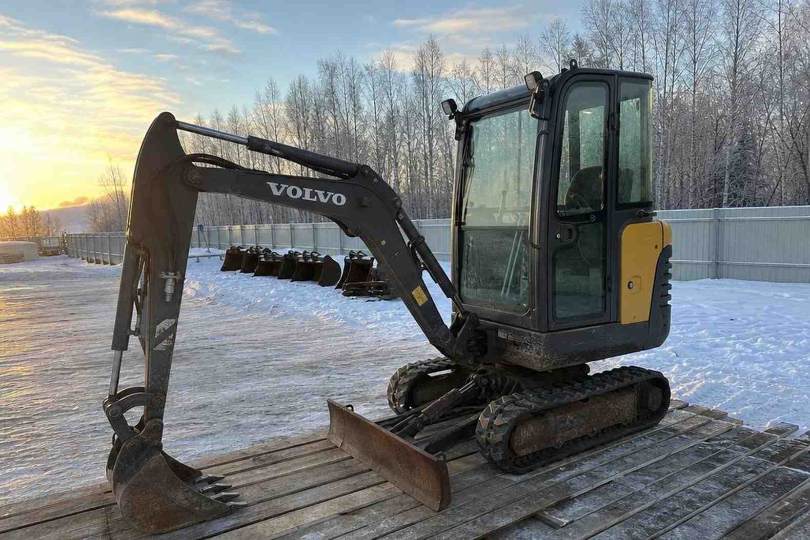 мини-экскаватор Sunward SWE08 на деревянных подкладках на зимней стоянке