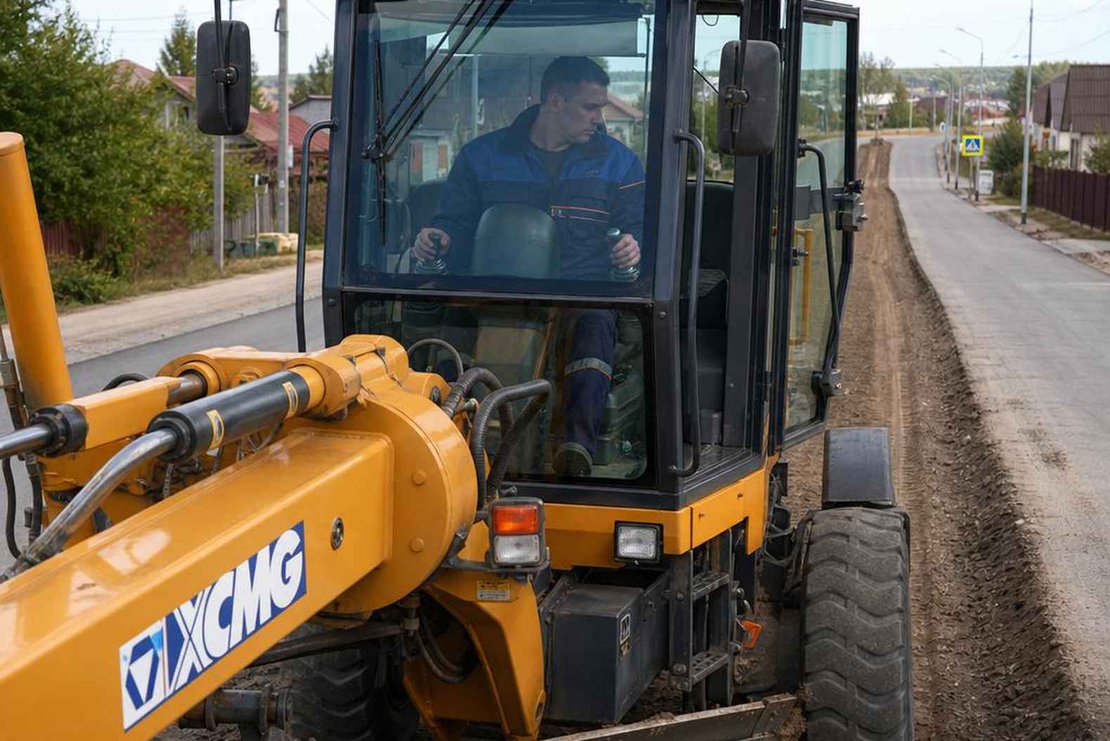 оператор управляет отвалом автогрейдера XCMG из кабины