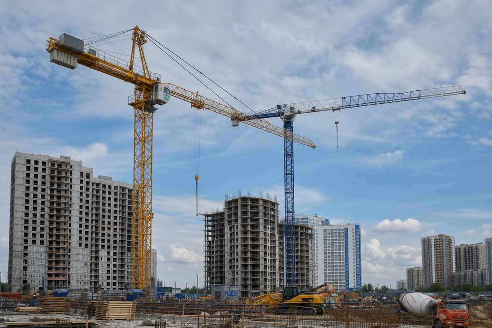 Три башенных крана разных производителей на строительной площадке